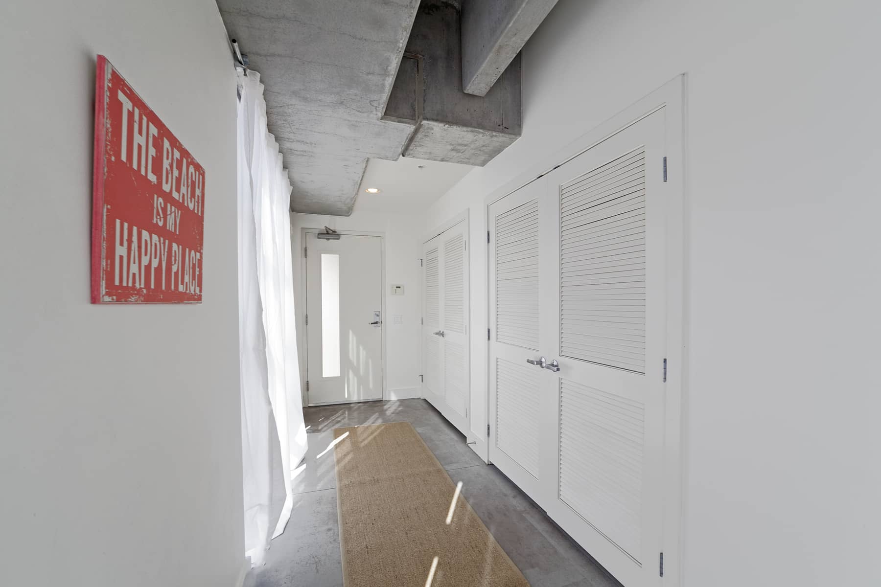  The long entry has a wall of windows along one side, and, along the other, a large coat/utility closet as well as a washer/dryer area. 