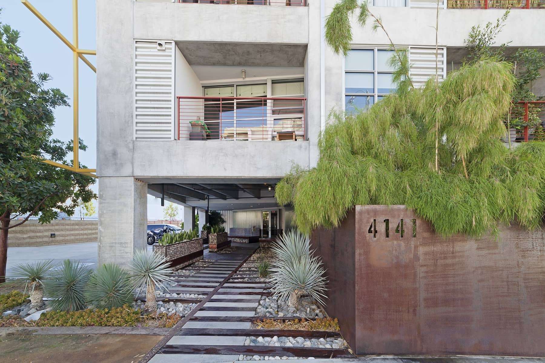  As you enter the building, there is a bit of a Brutalist architectural aesthetic going on. But when complemented by other zen-like design elements, everything from the balance of the wood and concrete pavers, to the artistic landscaping, you simply 