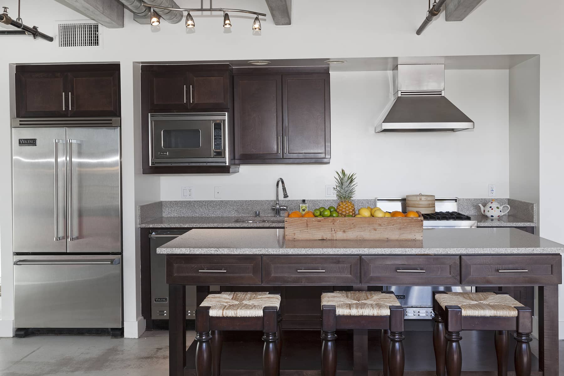  The kitchen boasts all Viking appliances and a huge island, featuring with a granite top that matches the counters along the sink and cooking area. And because this island is on wheels, you can esily move it around to reconfigure your space as neede